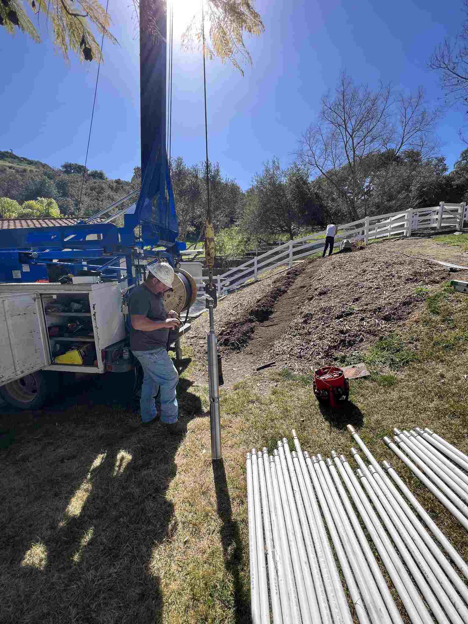 SCWS technician working on well pump with PVC pipe
